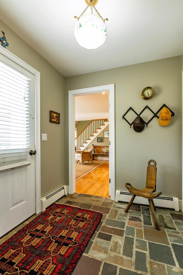 doorway featuring a baseboard heating unit, stairs, and brick floor