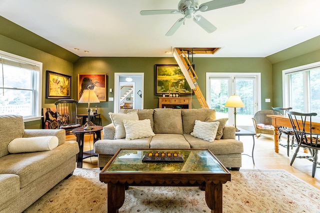 living room featuring light hardwood / wood-style floors, ceiling fan, and a healthy amount of sunlight