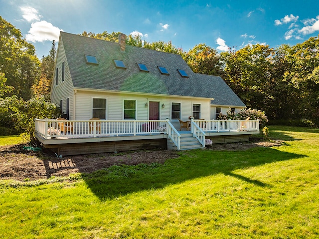 rear view of property featuring a chimney, a lawn, a shingled roof, and a deck