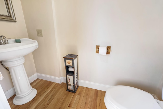 bathroom with toilet and hardwood / wood-style floors