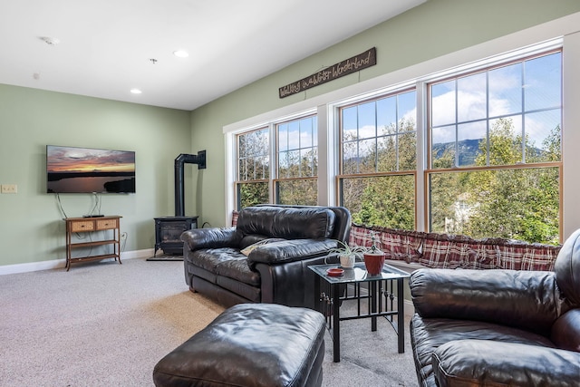 living room featuring light carpet and a wood stove