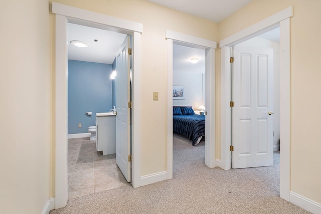 hallway featuring light colored carpet