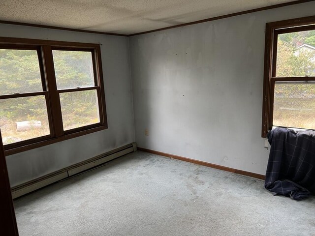 carpeted empty room with baseboard heating and a textured ceiling