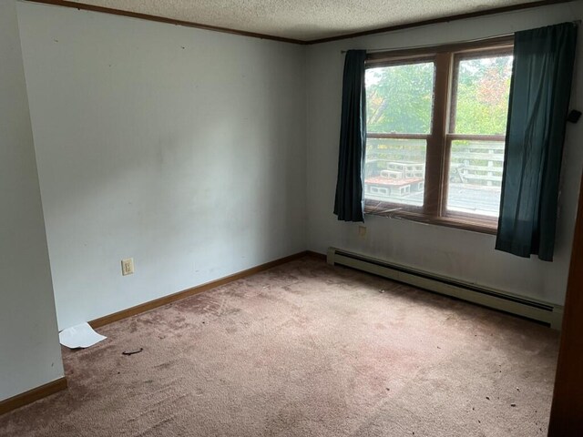 spare room with a textured ceiling, baseboard heating, and carpet flooring