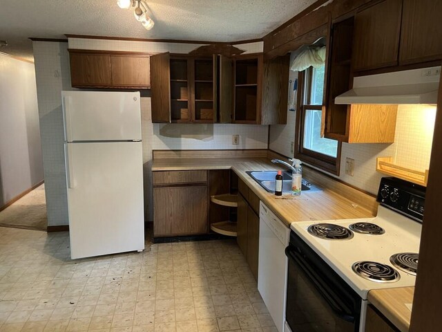 kitchen with a textured ceiling, sink, and white appliances