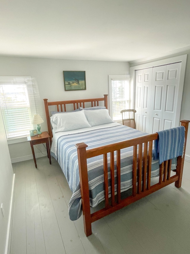 bedroom with a closet, baseboards, and wood finished floors