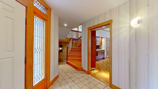 entrance foyer with light wood-type flooring and wood walls