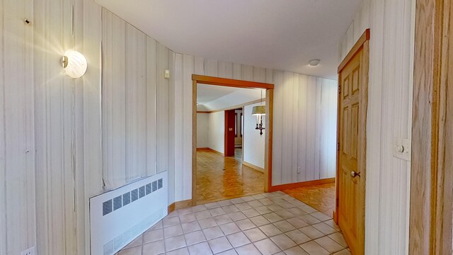 hallway with radiator heating unit and light tile patterned flooring