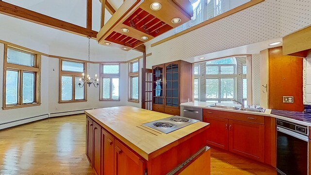 kitchen featuring a center island, stainless steel appliances, sink, a chandelier, and light wood-type flooring