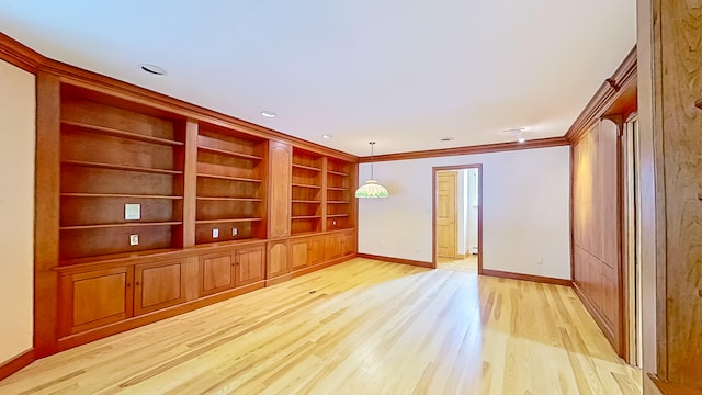 interior space featuring ornamental molding, built in features, and light hardwood / wood-style floors