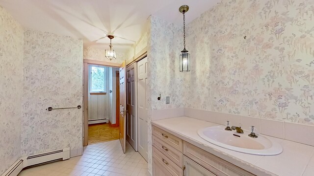 bathroom with vanity, baseboard heating, and tile patterned flooring