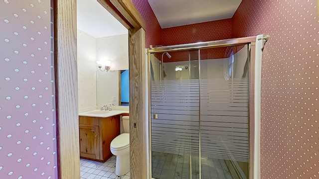 bathroom featuring tile patterned flooring, toilet, an enclosed shower, and vanity