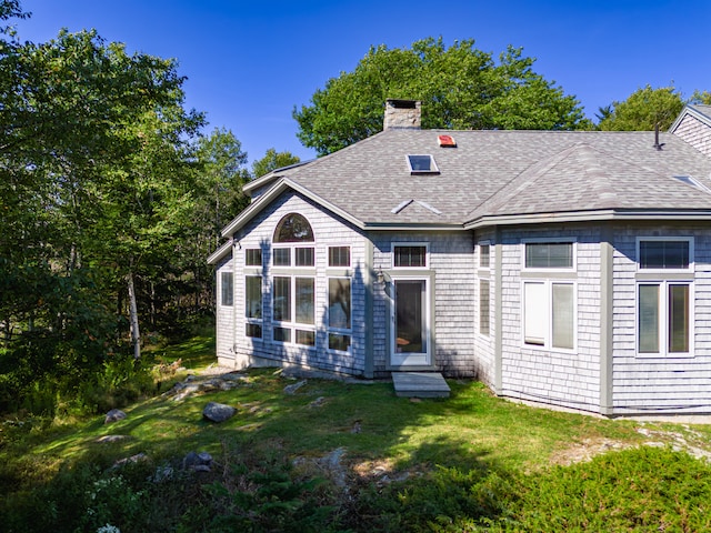 rear view of property with a lawn