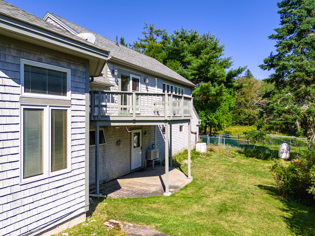 rear view of property featuring a yard, a patio area, and a deck