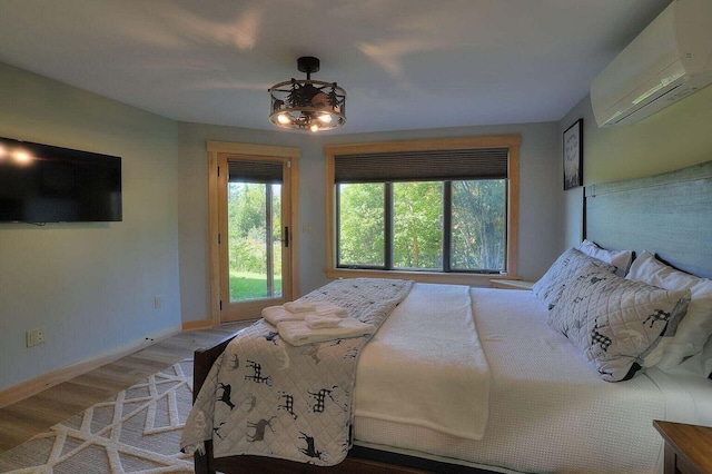 bedroom featuring a wall unit AC and wood-type flooring