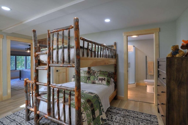 bedroom featuring ensuite bath and light wood-type flooring