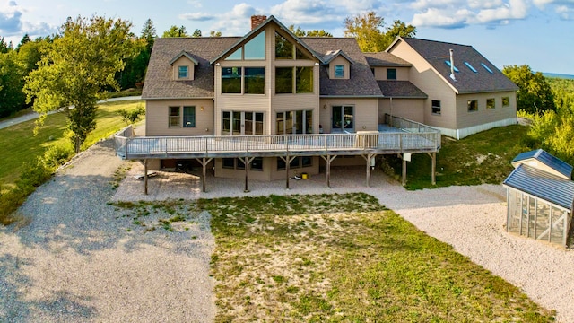 back of house featuring a lawn and a deck