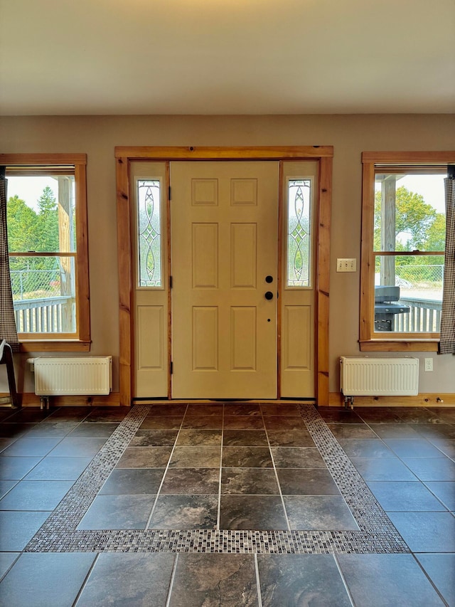 foyer featuring radiator and a wealth of natural light