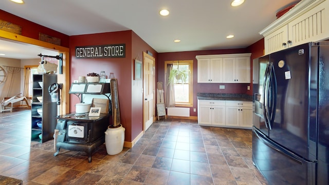 kitchen with black fridge and white cabinets