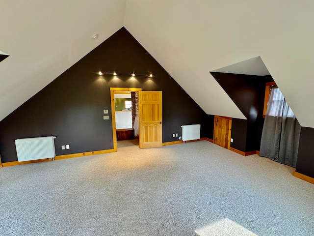 bonus room featuring lofted ceiling, carpet, and radiator