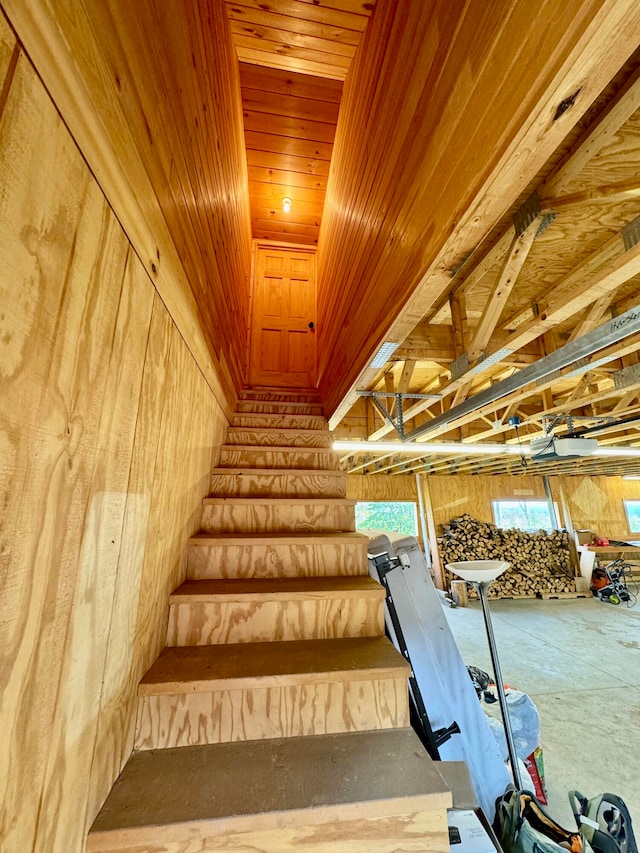 stairs with wooden ceiling and wood walls