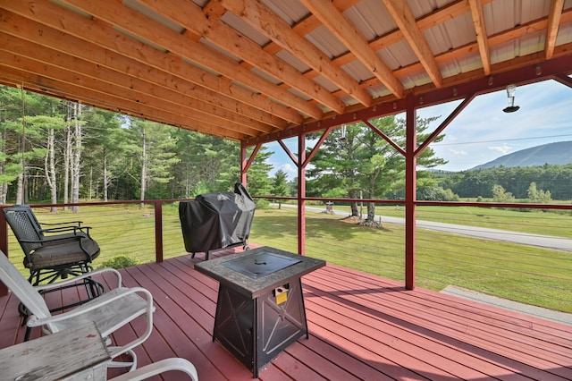 deck with a yard, area for grilling, and a mountain view