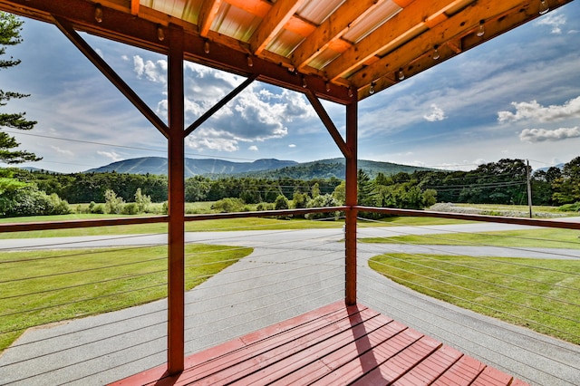 wooden deck featuring a lawn and a mountain view