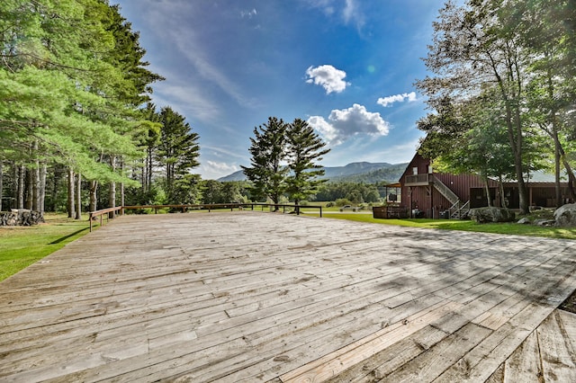 wooden deck featuring a mountain view and a yard