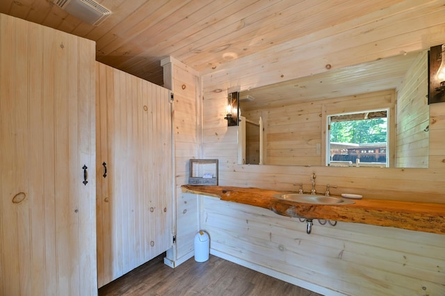 bathroom featuring wood finished floors, wooden ceiling, vanity, and wood walls