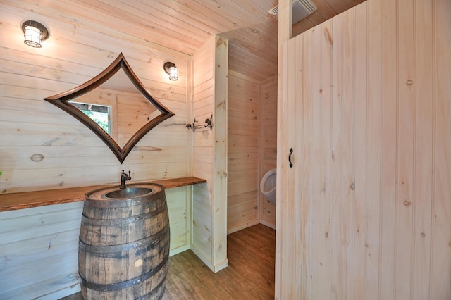 bathroom with wooden ceiling, wooden walls, wood finished floors, and visible vents