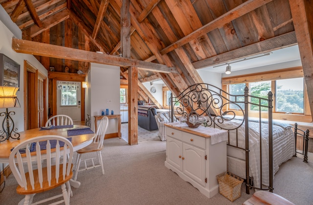 bedroom featuring light colored carpet, beamed ceiling, and high vaulted ceiling