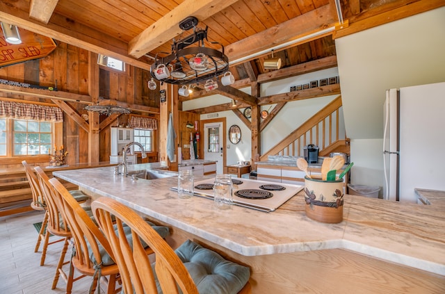 kitchen featuring sink, white appliances, wooden walls, light hardwood / wood-style flooring, and wooden ceiling