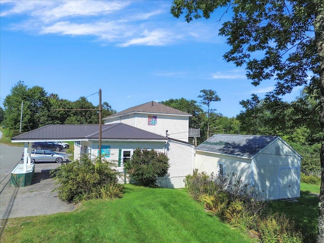 view of home's exterior with a yard, a storage shed, and a carport