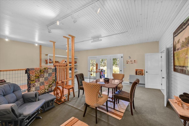 carpeted dining area featuring french doors and rail lighting