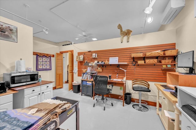 office space featuring built in desk, rail lighting, and a wall unit AC