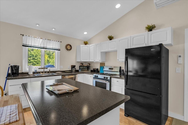 kitchen with light wood-type flooring, high vaulted ceiling, stainless steel appliances, sink, and white cabinets