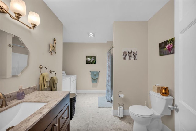 bathroom featuring vanity, toilet, and washing machine and dryer