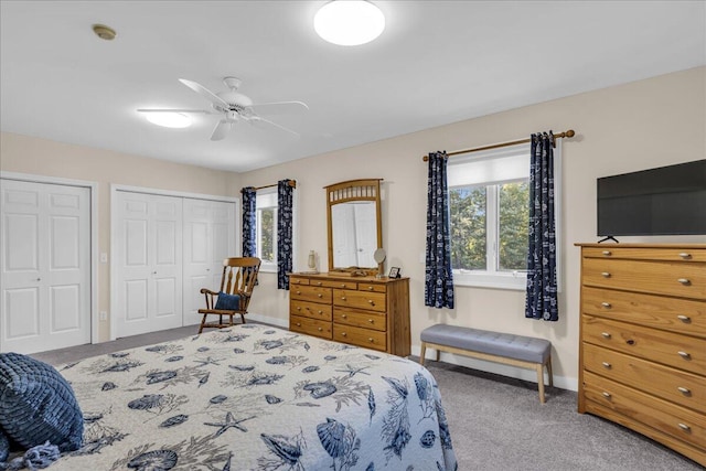 bedroom featuring multiple windows, ceiling fan, multiple closets, and carpet floors