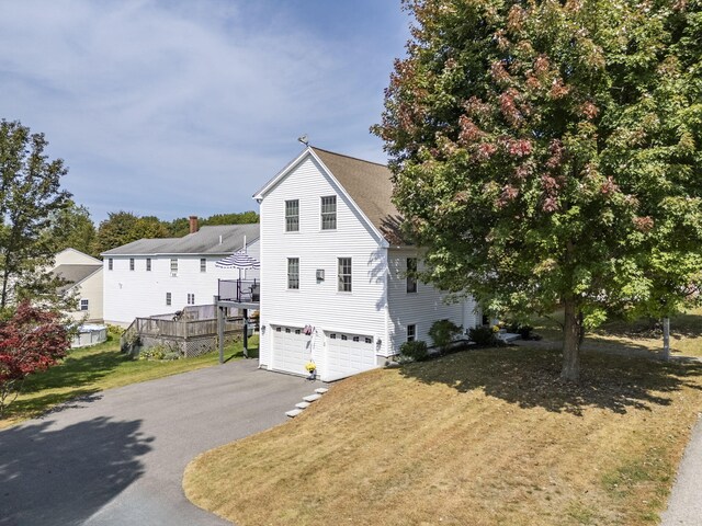 view of side of home featuring a yard and a garage