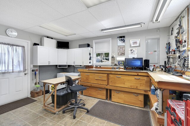 office space featuring a workshop area, light tile patterned flooring, a healthy amount of sunlight, and a paneled ceiling