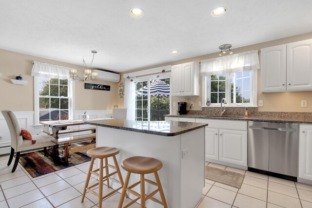 kitchen with white cabinets, a chandelier, a center island, and stainless steel dishwasher