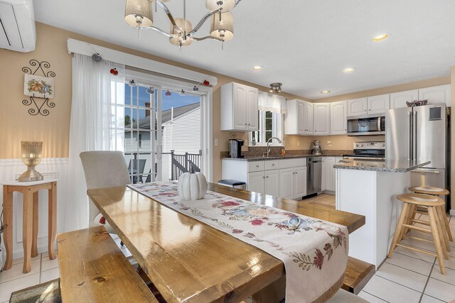 tiled dining space featuring a notable chandelier and sink