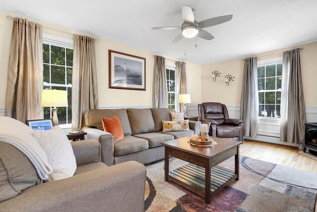 living room featuring light hardwood / wood-style flooring, a wealth of natural light, and ceiling fan