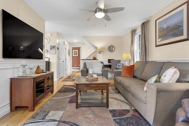 living room with ceiling fan and light hardwood / wood-style flooring