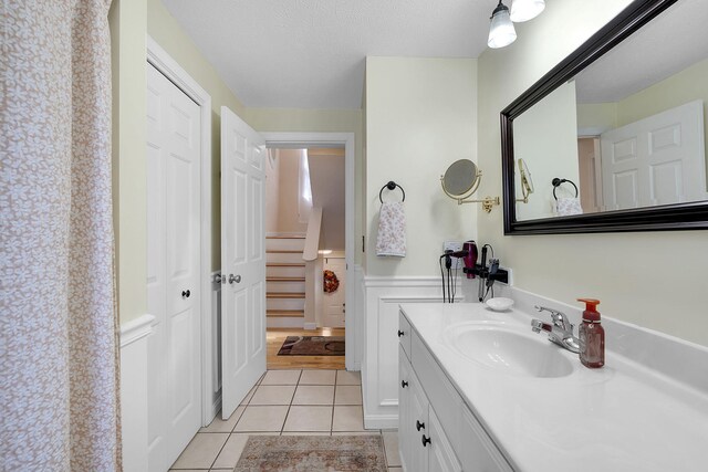 bathroom with tile patterned flooring, a textured ceiling, and vanity