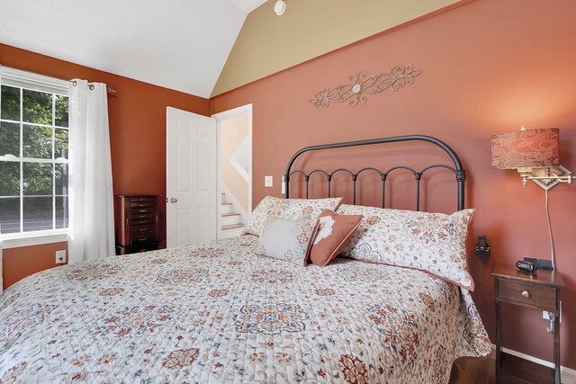 bedroom featuring lofted ceiling and hardwood / wood-style floors