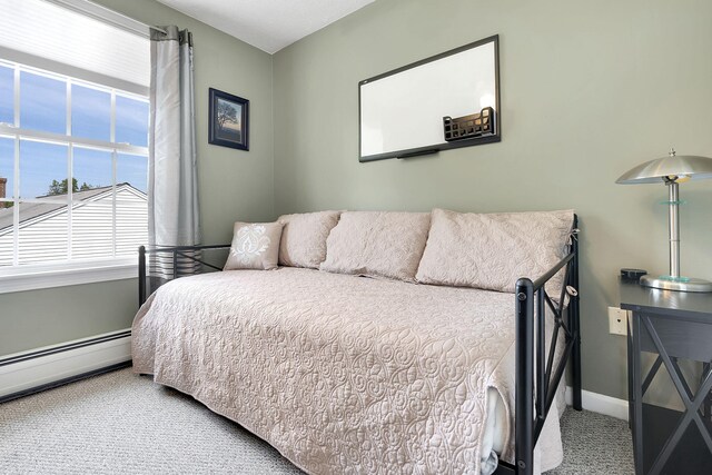 carpeted bedroom featuring a baseboard heating unit