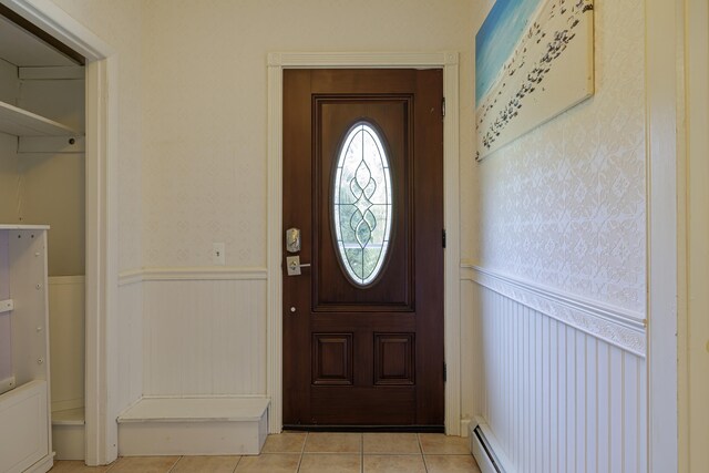 entrance foyer featuring a baseboard heating unit and light tile patterned flooring