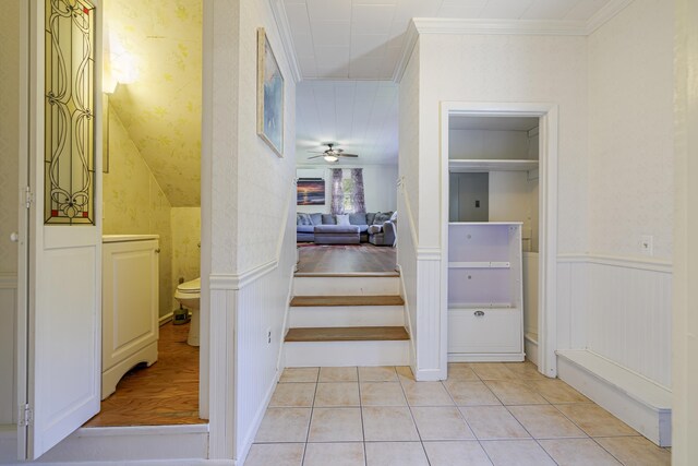 hallway with ornamental molding and light hardwood / wood-style floors