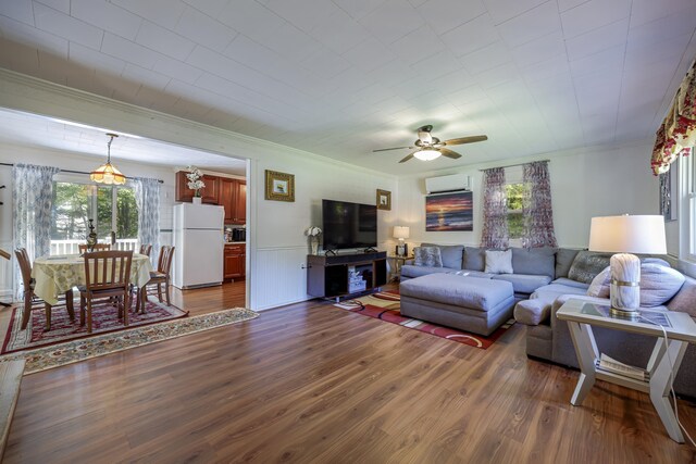 living room featuring crown molding, ceiling fan, dark hardwood / wood-style floors, and a wall mounted AC